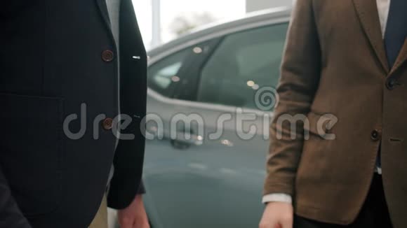 握手动作慢男性顾客在展厅买车拿钥匙视频的预览图