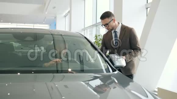 销售经理和坐在展厅里选择汽车的客户交谈视频的预览图