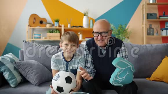 兴奋的人们祖父和孙子在电视上看足球的肖像视频的预览图