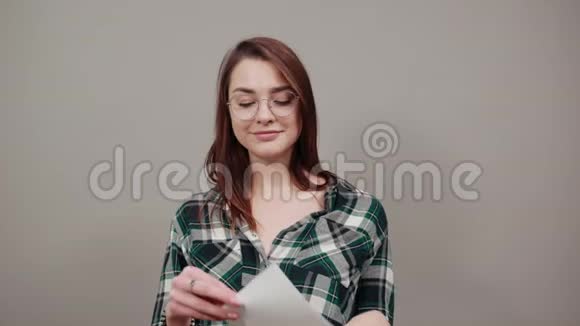 幸福的女人戴着眼镜拿着一张白纸微笑着视频的预览图