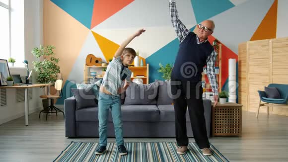 爷爷孙子在家一起做运动的慢动作视频的预览图