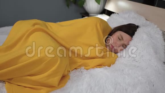 女孩躺在被黄色格子包裹的床上她颤抖着冻住了她的身体感冒流感病毒急性呼吸道疾病视频的预览图