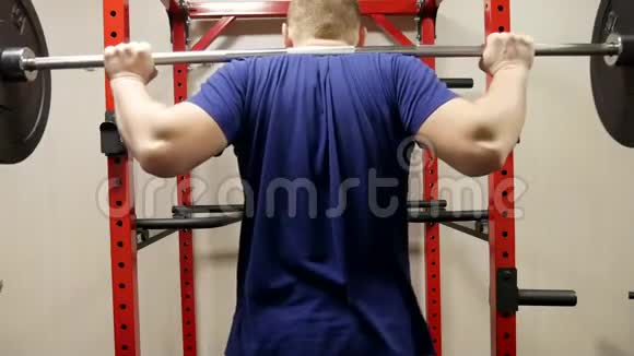 年轻肌肉男进行背部蹲式运动视频的预览图