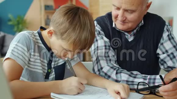孙子和爷爷在家做家庭作业然后做击掌竖起大拇指视频的预览图