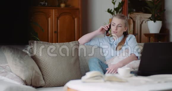 轻松微笑的女人在家里用手机说话视频的预览图