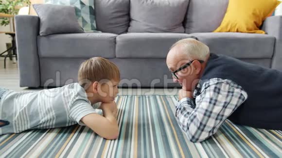 祖父与好奇的孩子交谈分享在家里放松的经历视频的预览图