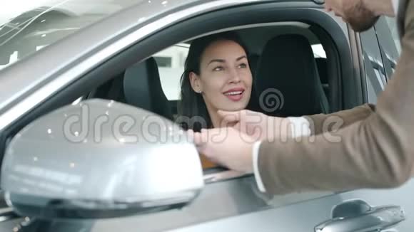 在经销商控股控制器与汽车销售经理交谈的美女视频的预览图