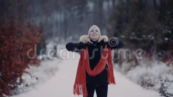 积极的女人在雪地上跳跃在冬天玩围巾视频的预览图
