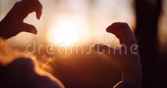 女人用心形的手在阳光下视频的预览图