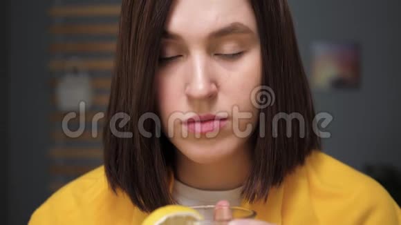 女孩正在喝红茶看着相机迷人的年轻女子病了喝柠檬茶感冒流感视频的预览图