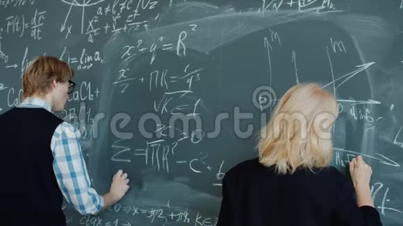 人们老师在黑板上写公式忙于教育过程视频的预览图