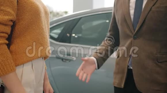 汽车经销店男女手摇拿送钥匙动作缓慢视频的预览图
