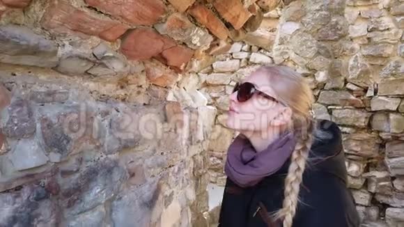 女孩检查欧洲一座古老城堡的墙壁视频的预览图