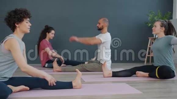 女瑜伽老师在课堂上向一群人展示体式视频的预览图