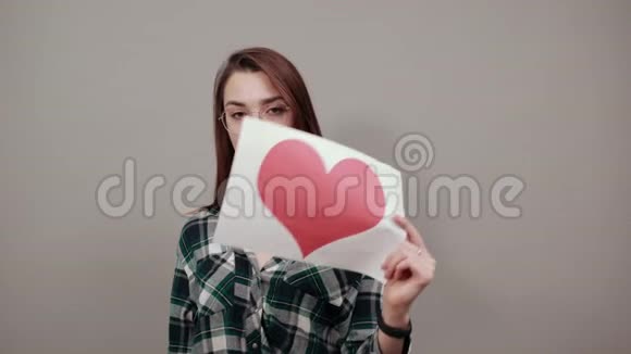 戴眼镜的女人手里拿着一张红心纸视频的预览图