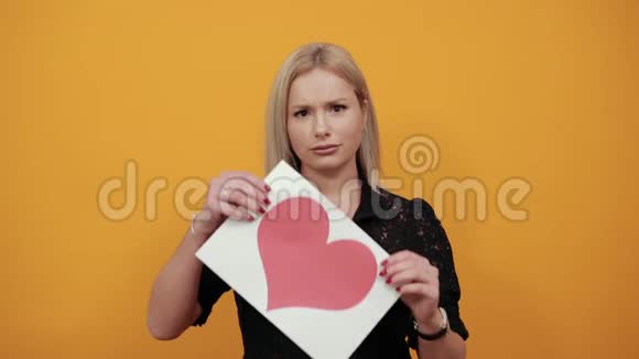 女孩心烦意乱女人不满地拿着一张红心的纸视频的预览图