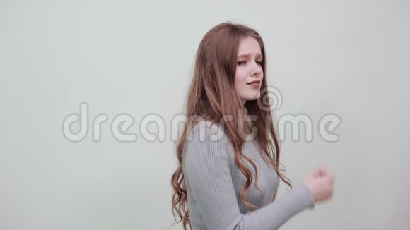 穿灰色毛衣的女人开心地笑着用手托着下巴视频的预览图