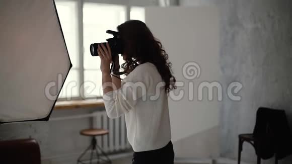 专业的女摄影师穿着休闲服在摄影棚拍照视频的预览图