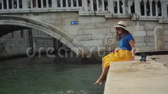 戴帽子的漂亮女人光着脚坐在石墩上泼水视频的预览图