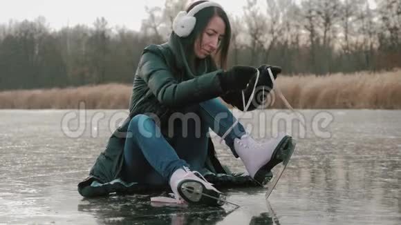 在寒冷的冬日一位年轻女子在结冰的湖面上滑冰户外冬季溜冰场上的溜冰者的腿人视频的预览图