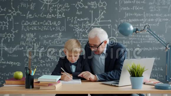 爱心爷爷教授在课堂上教小男孩孙子说写视频的预览图