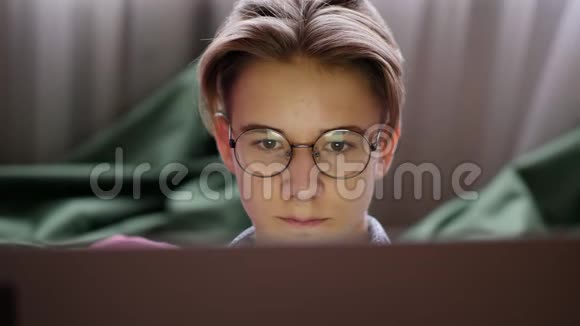 戴眼镜看手提电脑屏幕的少年视频的预览图