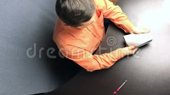 一个人手里捏着一本没有包装的圣经在彩色切片上分离粘页视频的预览图