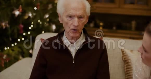 圣诞节期间和祖父在家聊天的女人视频的预览图