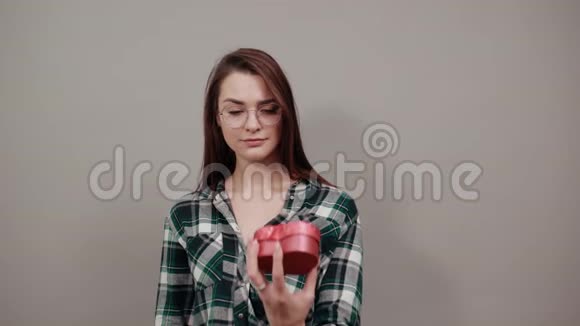 被侮辱的女人拿着礼物红色的盒子以手掌的形式停止视频的预览图