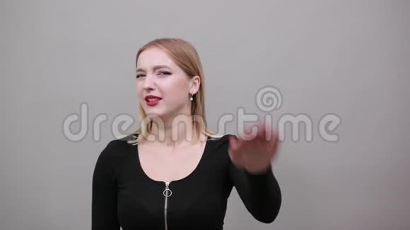 身穿黑色夹克的金发女孩愤怒的女人用手势停下来露出手掌视频的预览图