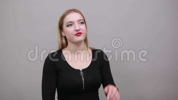 年轻的金发女孩穿着黑色夹克年轻的女人想把她的手放在下巴上视频的预览图