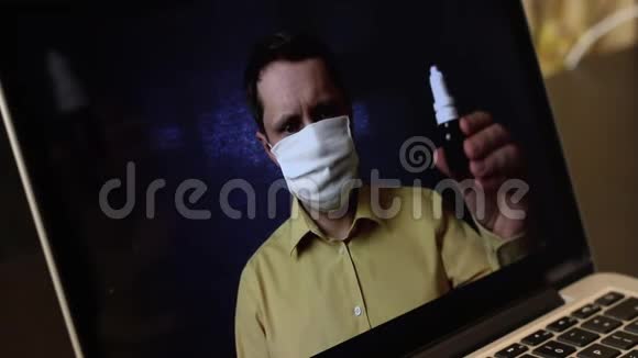 一位戴着医疗面具的视频博主正在笔记本电脑网络摄像头上录制广告视频他向他的订阅者介绍视频的预览图