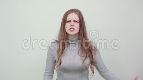 一个穿灰色毛衣的女人一个愤怒的愤怒的女士愤怒地握着拳头视频的预览图