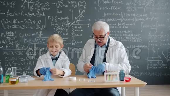 儿童和教师在化学实验前戴上橡胶手套视频的预览图