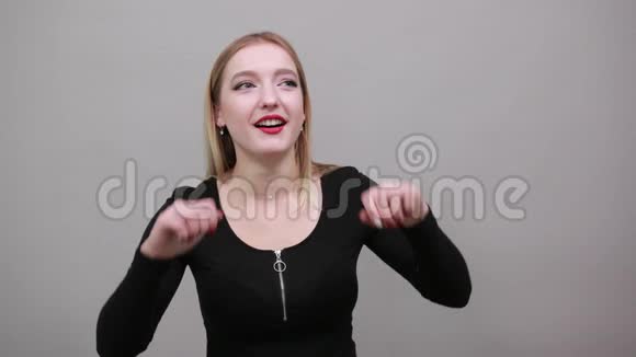 年轻的金发女孩穿着黑色夹克滑稽的女人做鬼脸视频的预览图