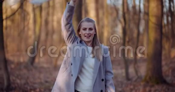 幸福的女人一边微笑一边在树林里移动围巾视频的预览图