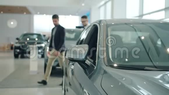 男买家在展厅选购新车与经理洽谈业务关注车辆反光镜视频的预览图