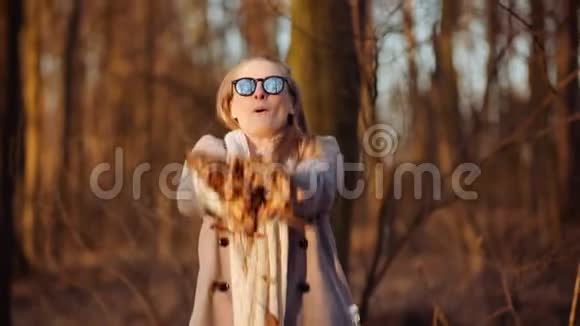 积极快乐的女人在公园秋天扔树叶视频的预览图
