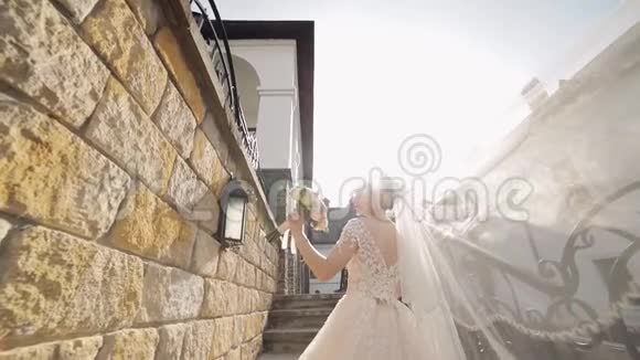 美丽可爱的新娘穿着婚纱站在石阶上慢动作视频的预览图