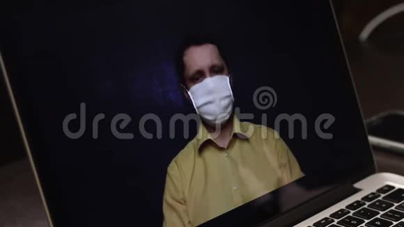 一位戴着医疗面具的视频博主正在笔记本电脑网络摄像头上录制广告视频他宣传喷喉喷雾剂视频的预览图