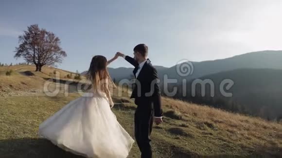 新婚夫妇白人新郎和新娘在山坡上跳舞新婚夫妇视频的预览图