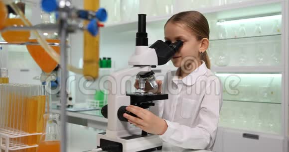 在学校化学实验室使用显微镜的孩子在实验室学习的学生孩子在科学课上的女孩实验视频的预览图