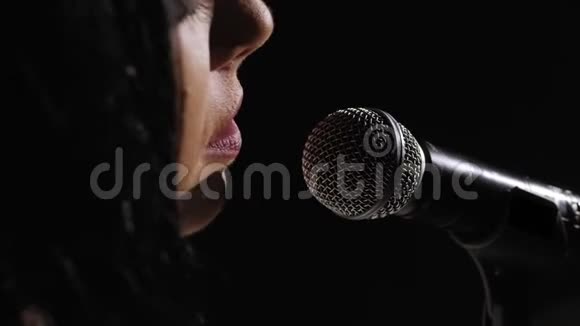 在黑色背景上用麦克风特写歌手的脸视频的预览图