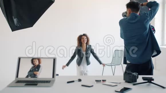 欢乐的女孩在摄影棚拍照时为镜头跳跃而开心视频的预览图