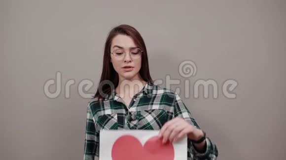 戴眼镜的疲惫的女人拿着一张红心的纸视频的预览图