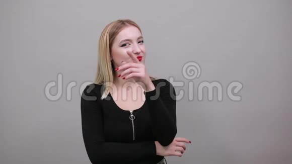 穿黑夹克的女孩在灰色背景下聪明的女人想手牵手面对视频的预览图