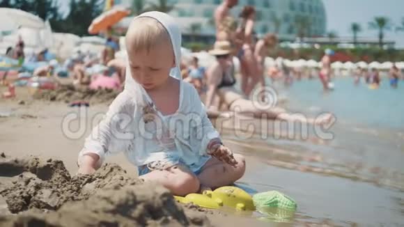 那个可爱的小男孩在海边玩沙子玩具孩子们在暑假在海滩度假视频的预览图