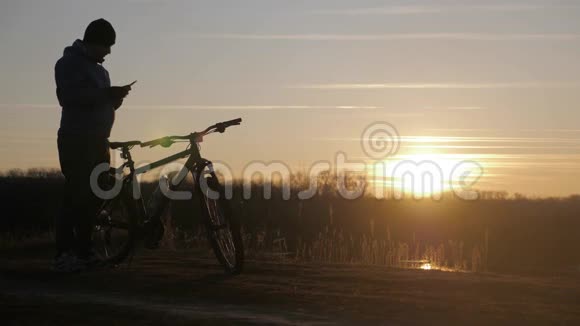 日落时骑自行车的山地自行车骑手的轮廓运动旅行和积极的生活理念视频的预览图