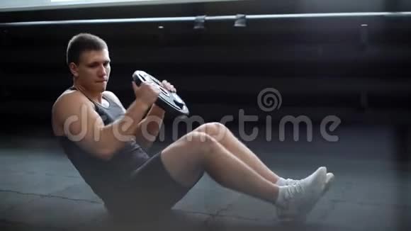 运动型肌肉男用杠铃做俄罗斯扭体运动视频的预览图