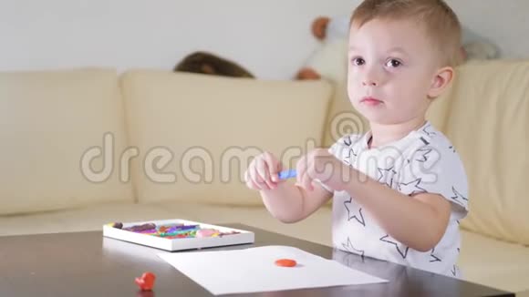 孩子在家玩塑料有创意的孩子在桌子上玩粘土成型视频的预览图